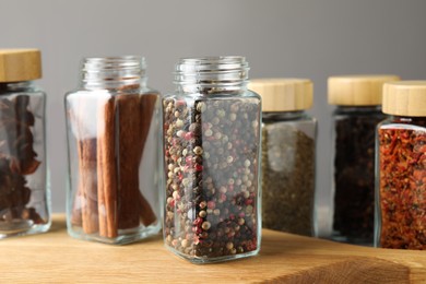 Photo of Different spices in glass jars on table