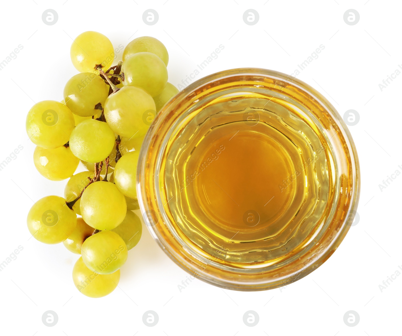 Photo of Ripe grapes and glass of tasty juice isolated on white