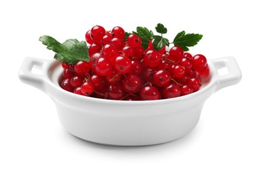 Photo of Ripe red currants with green leaves in bowl isolated on white