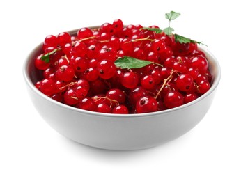 Photo of Ripe red currants with green leaves in bowl isolated on white