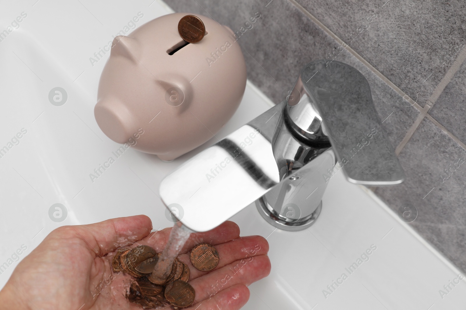 Photo of Water saving concept. Woman with coins under tap water in bathroom