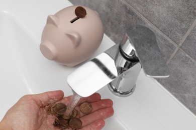 Photo of Water saving concept. Woman with coins under tap water in bathroom