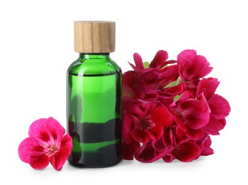 Photo of Geranium essential oil in bottle and beautiful flowers isolated on white