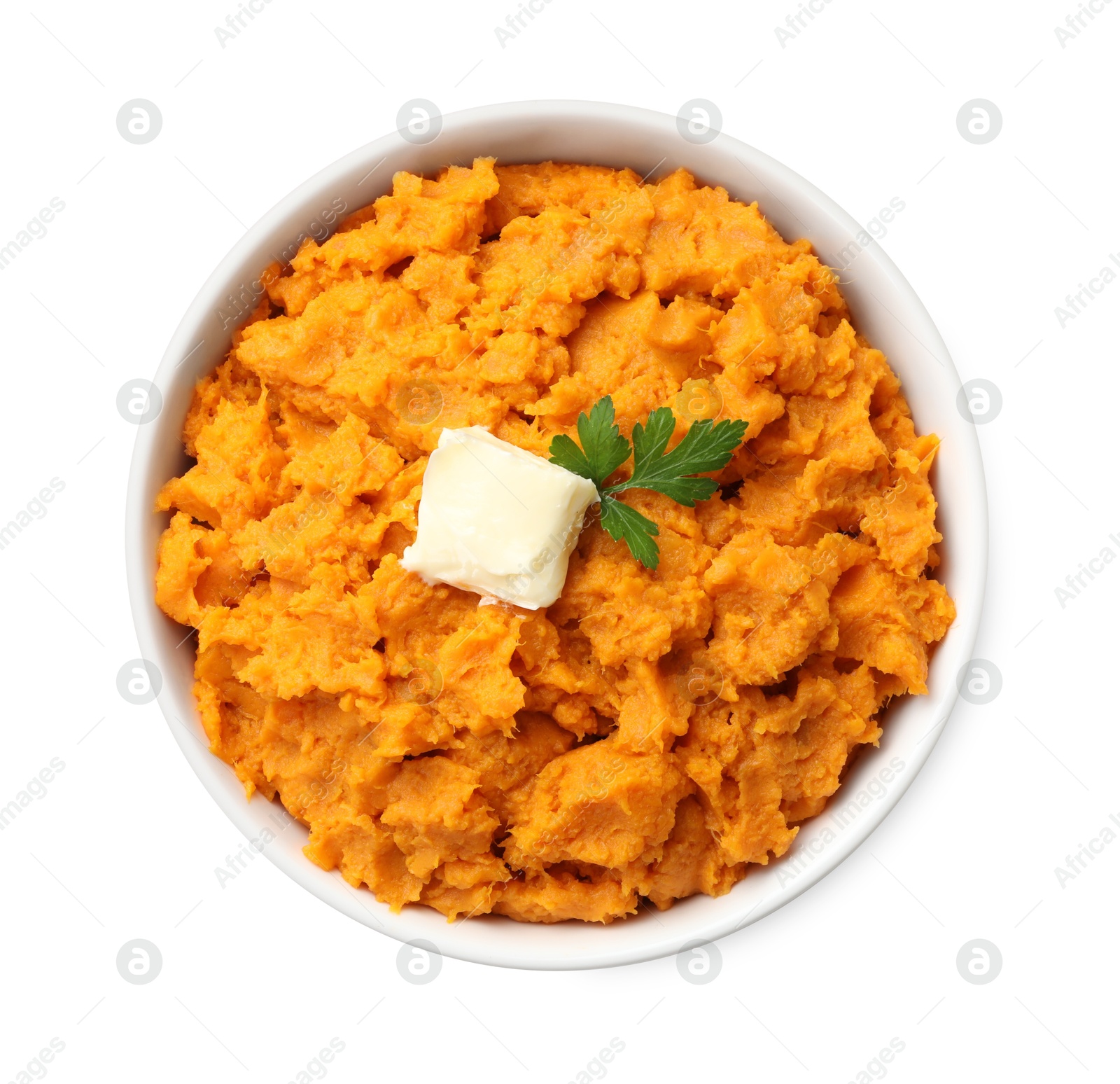 Photo of Delicious mashed sweet potatoes with butter and parsley in bowl isolated on white, top view