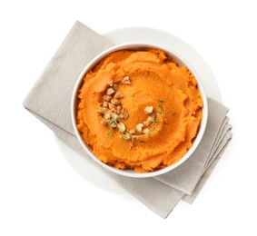 Photo of Delicious mashed sweet potatoes and walnuts in bowl isolated on white, top view