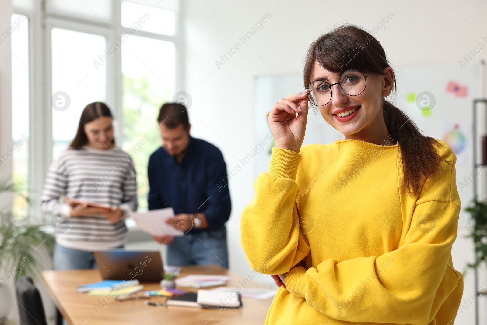 Photo of Portrait of happy young designer with glasses in office