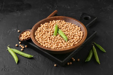 Dried peas and pods with fresh ones on dark textured table, closeup