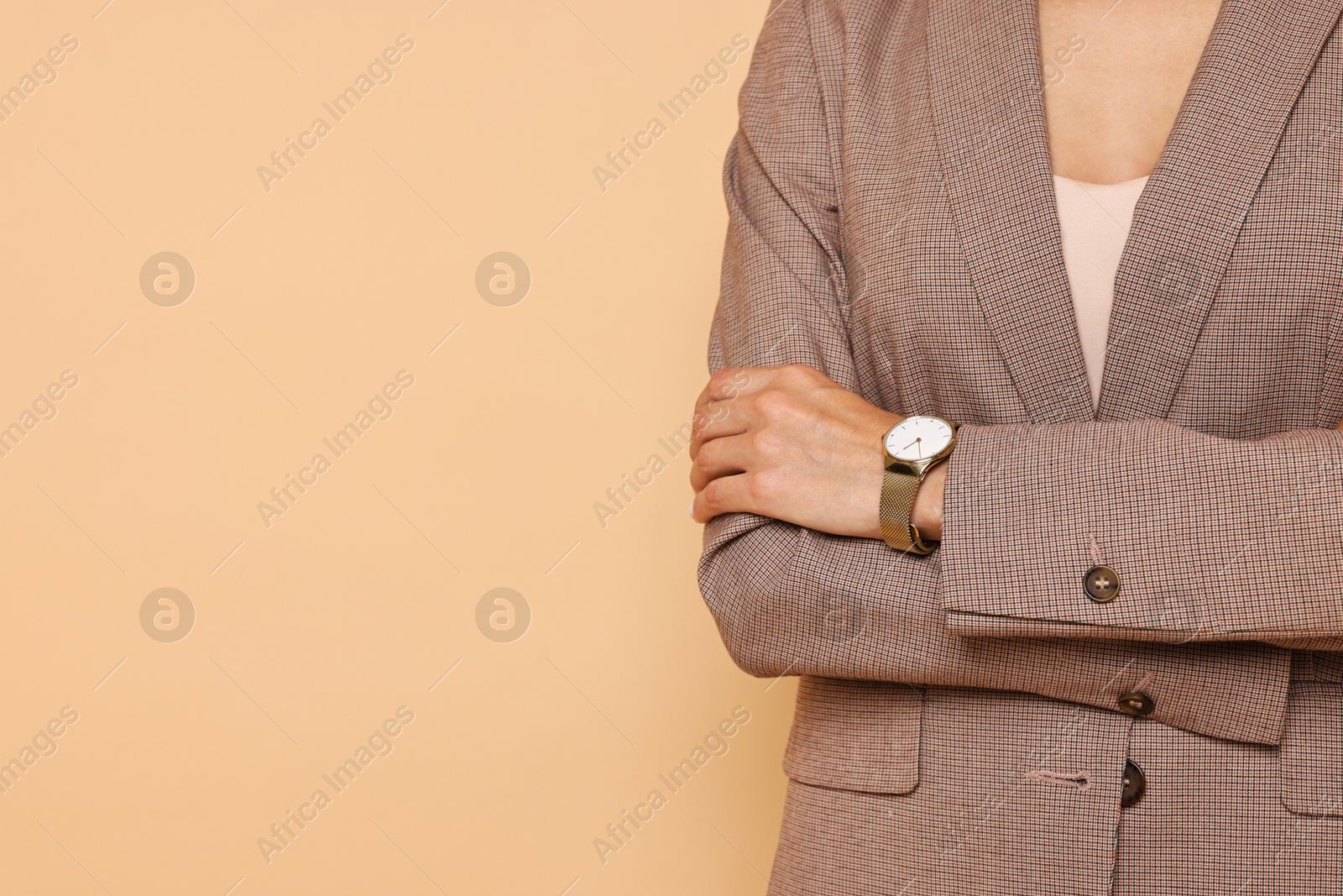 Photo of Woman in stylish jacket on pale orange background, closeup. Space for text