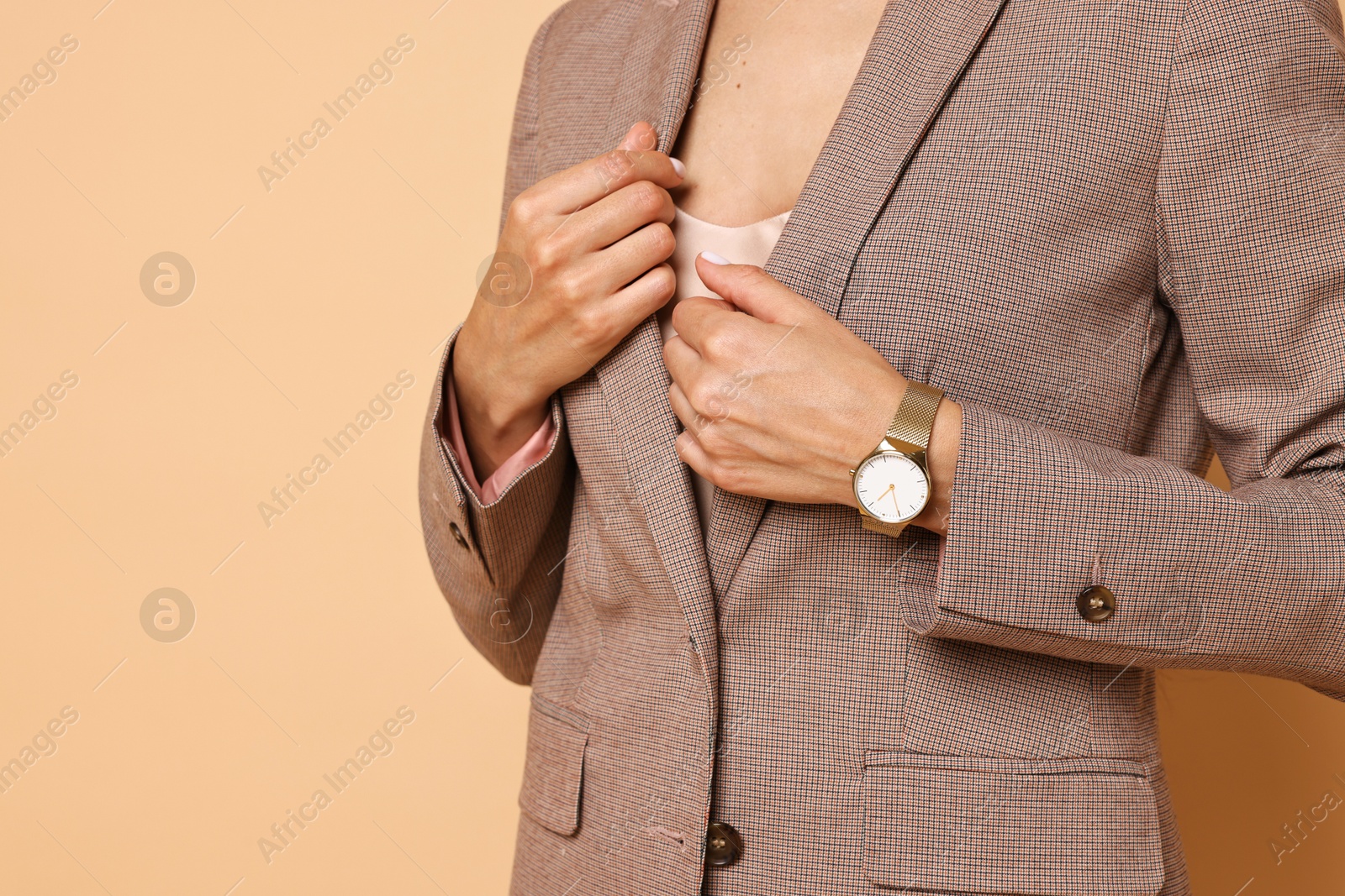 Photo of Woman in stylish jacket on pale orange background, closeup. Space for text