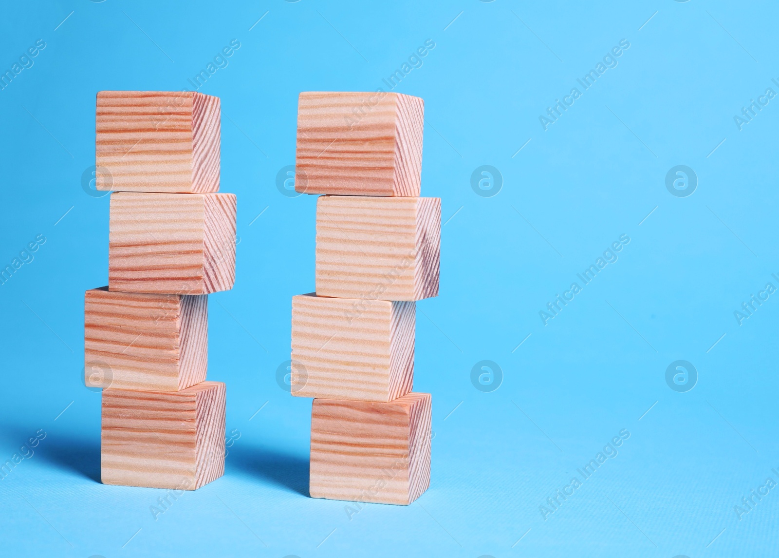 Photo of Many blank wooden cubes on light blue background, space for text