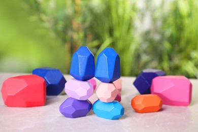 Photo of Many colorful balancing stones on light grey outdoors