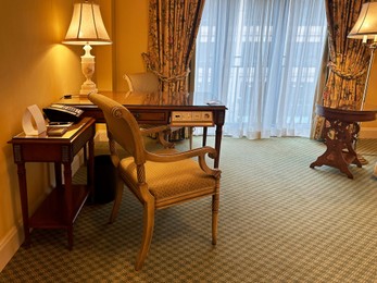 Stylish hotel room interior with comfortable furniture and large window