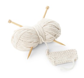 Photo of Skein of soft yarn with knitting needles and pattern sample isolated on white