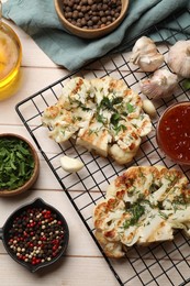 Photo of Delicious grilled cauliflower steaks with sauce and spices on wooden table, flat lay