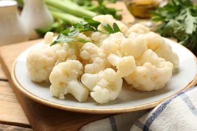 Photo of Tasty cauliflower with parsley on wooden table, closeup