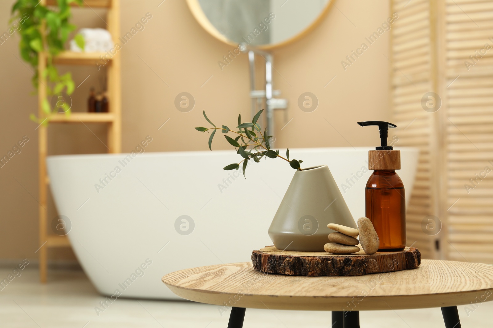 Photo of Personal care product, stones and vase on table in bathroom