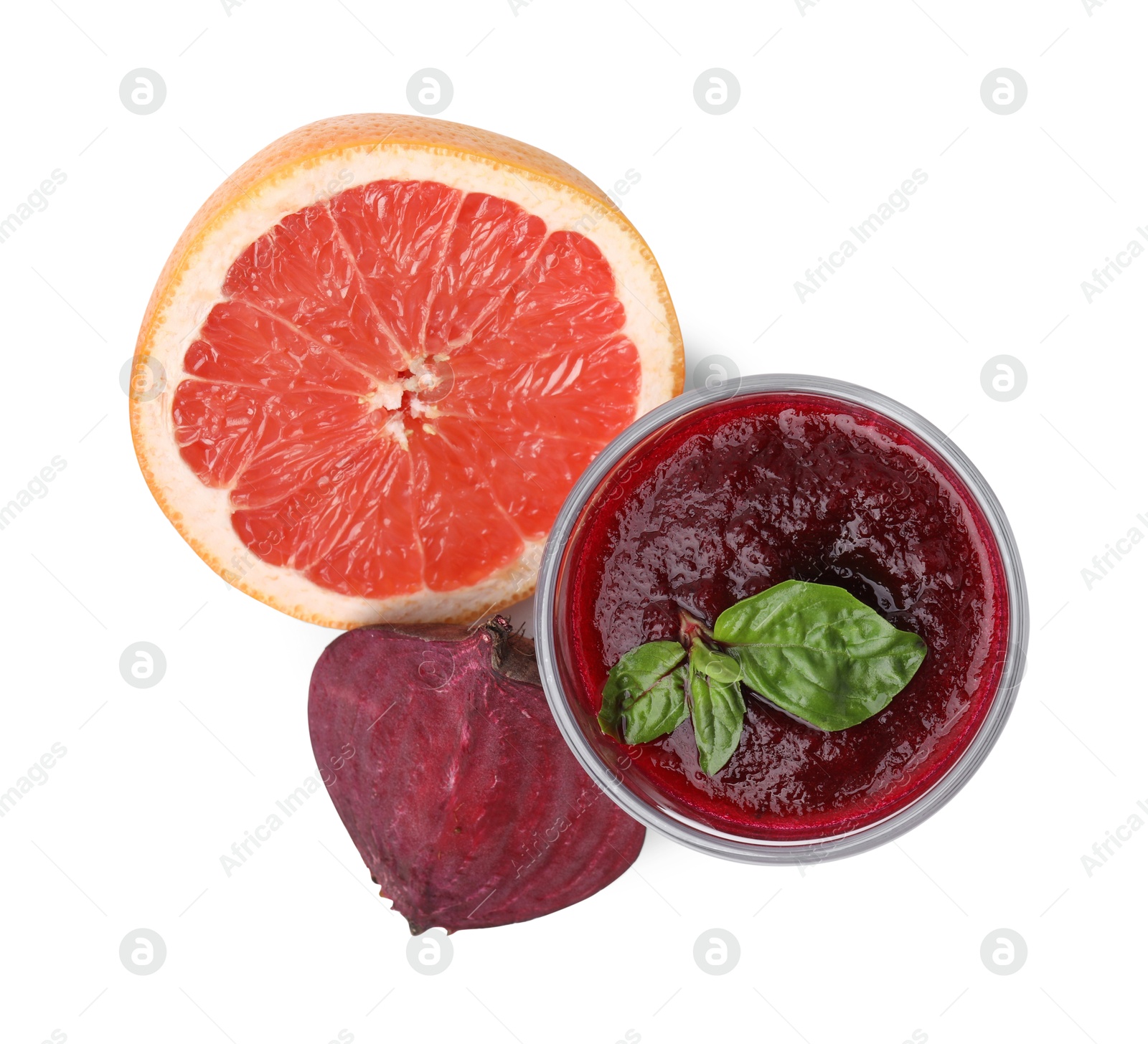 Photo of Tasty beetroot smoothie with basil in glass, fresh vegetable and grapefruit isolated on white, top view. Vegan drink