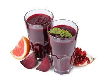 Photo of Fresh beetroot smoothie in glasses, grapefruit, beet and pomegranate isolated on white