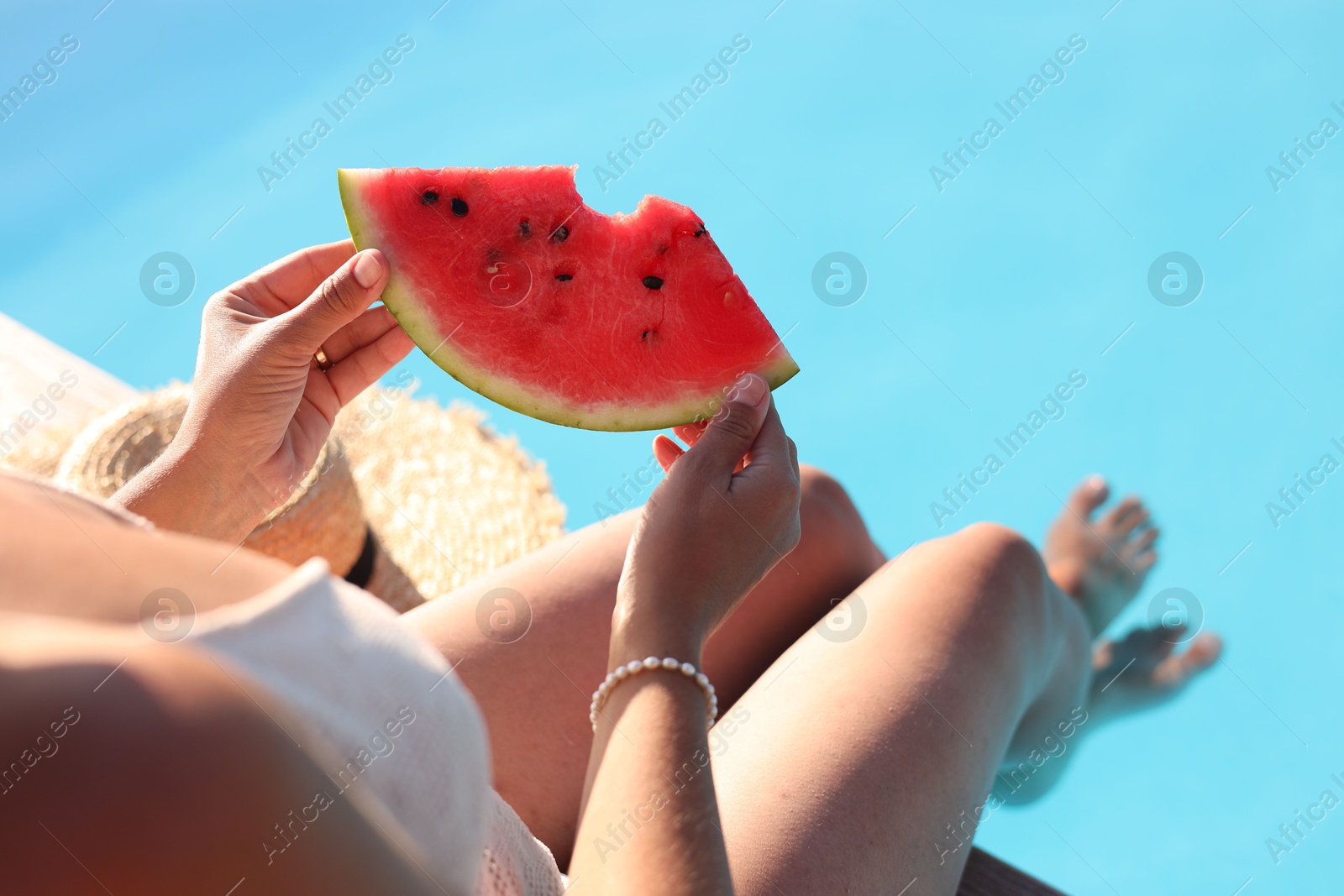 Photo of Woman with slice of juicy watermelon near swimming pool outdoors, closeup