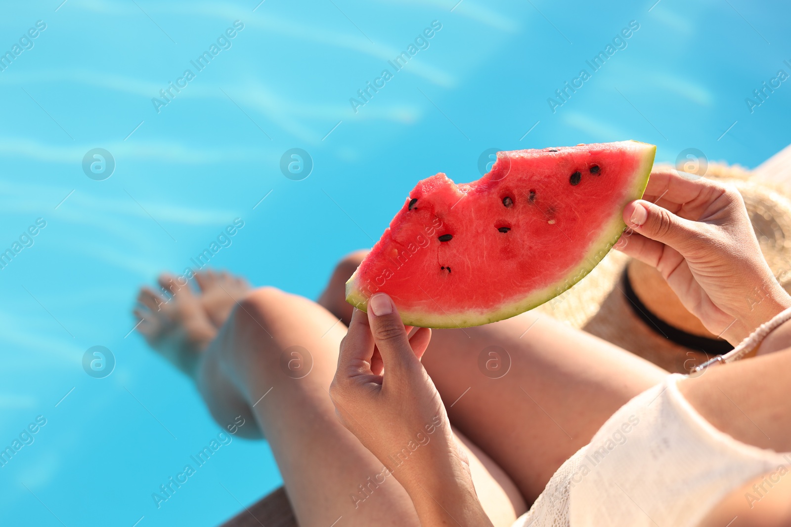 Photo of Woman with slice of juicy watermelon near swimming pool outdoors, closeup