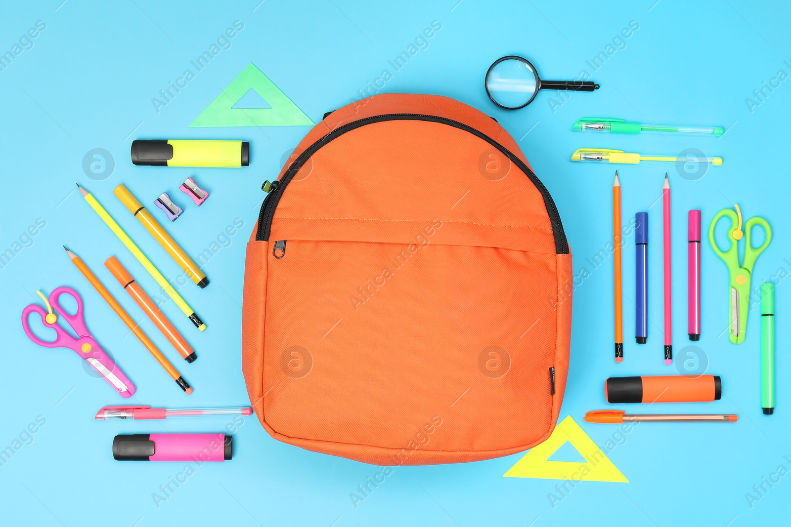 Photo of Backpack and different school supplies on light blue background, flat lay