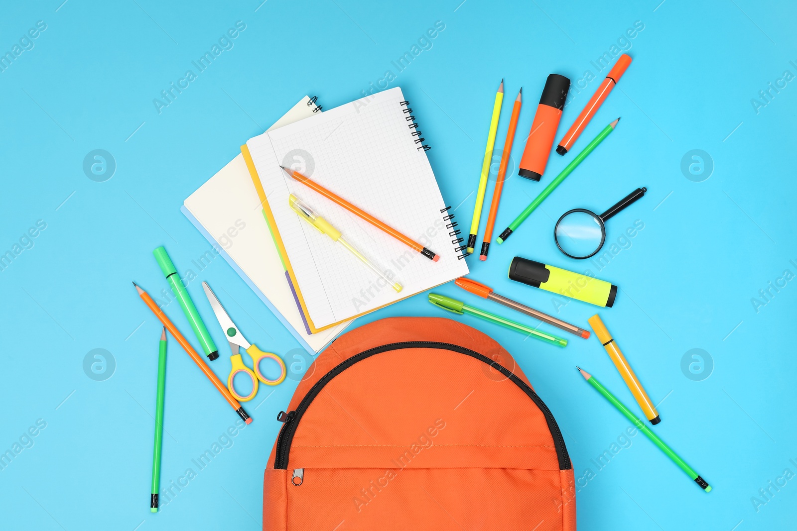 Photo of Backpack and different school supplies on light blue background, flat lay