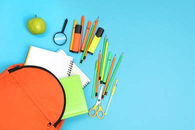 Photo of Backpack and different school supplies on light blue background, flat lay. Space for text