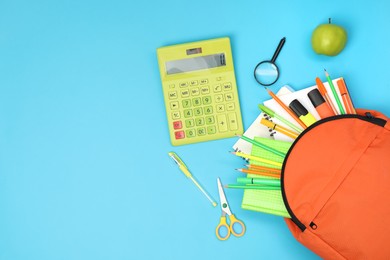 Photo of Backpack and different school supplies on light blue background, flat lay. Space for text