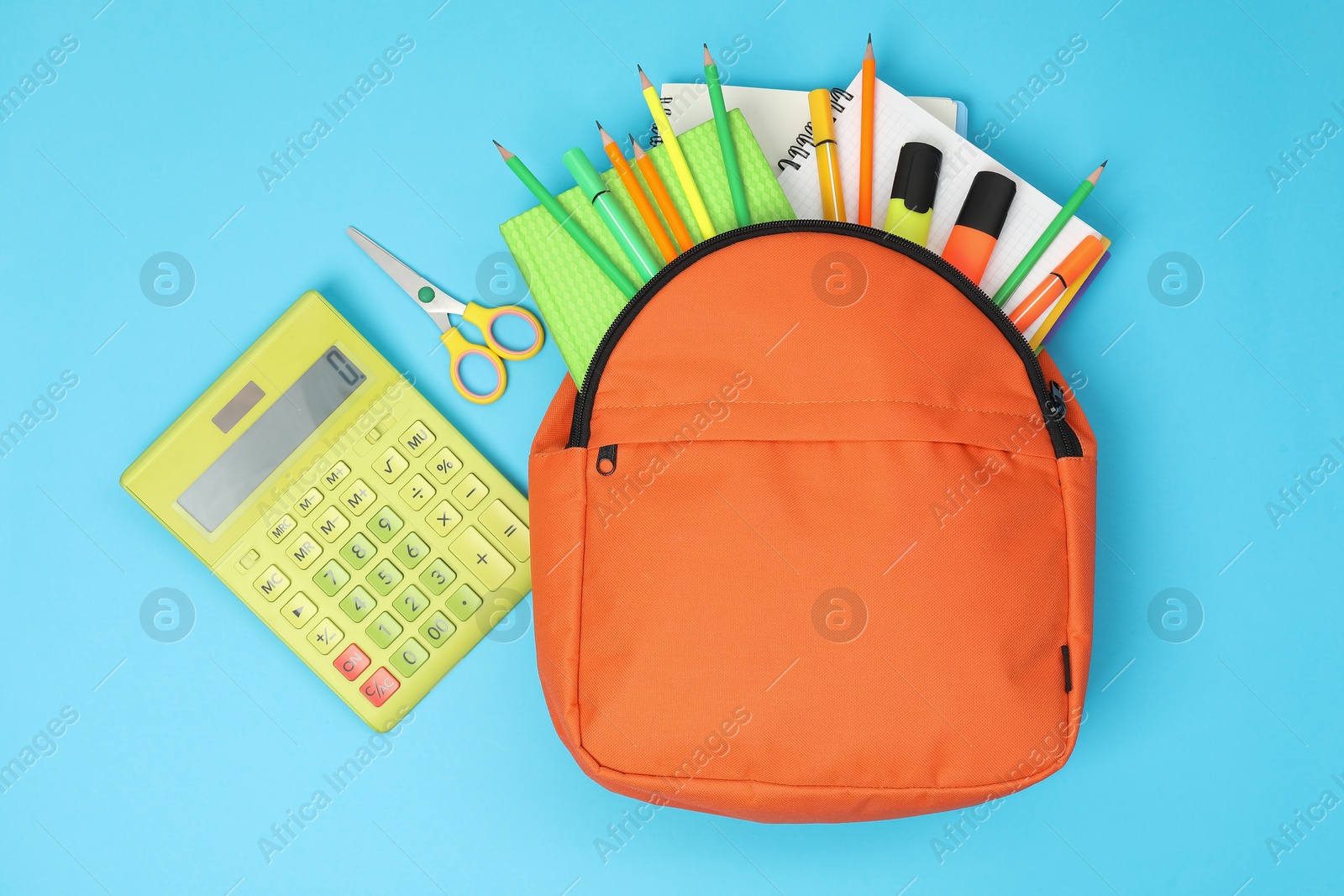 Photo of Backpack and different school supplies on light blue background, flat lay