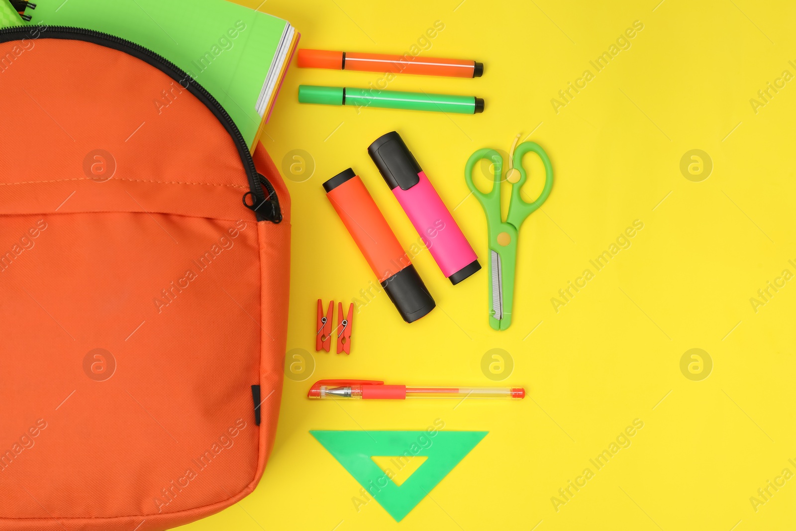 Photo of Backpack and different school supplies on yellow background, flat lay. Space for text