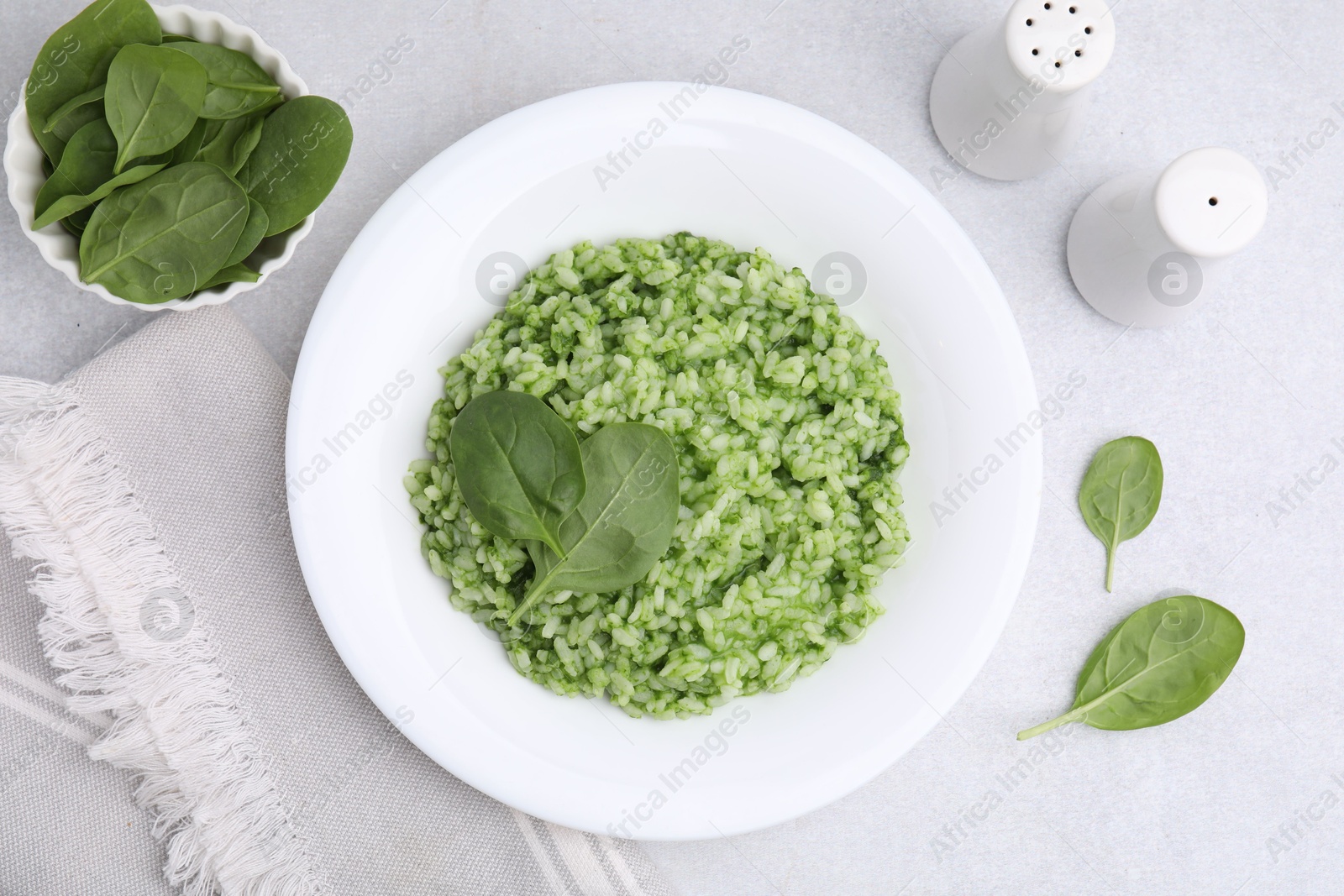 Photo of Delicious spinach risotto on light grey table