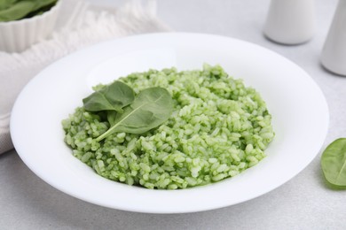 Photo of Delicious spinach risotto on light grey table, closeup