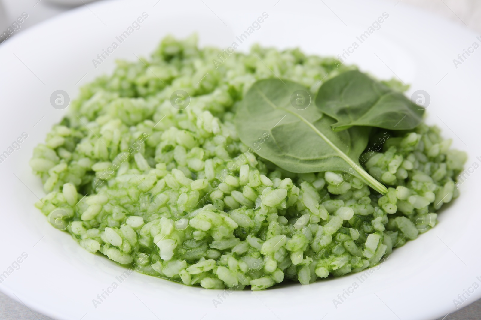 Photo of Delicious spinach risotto in plate, closeup view