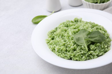 Photo of Delicious spinach risotto on light grey table, closeup