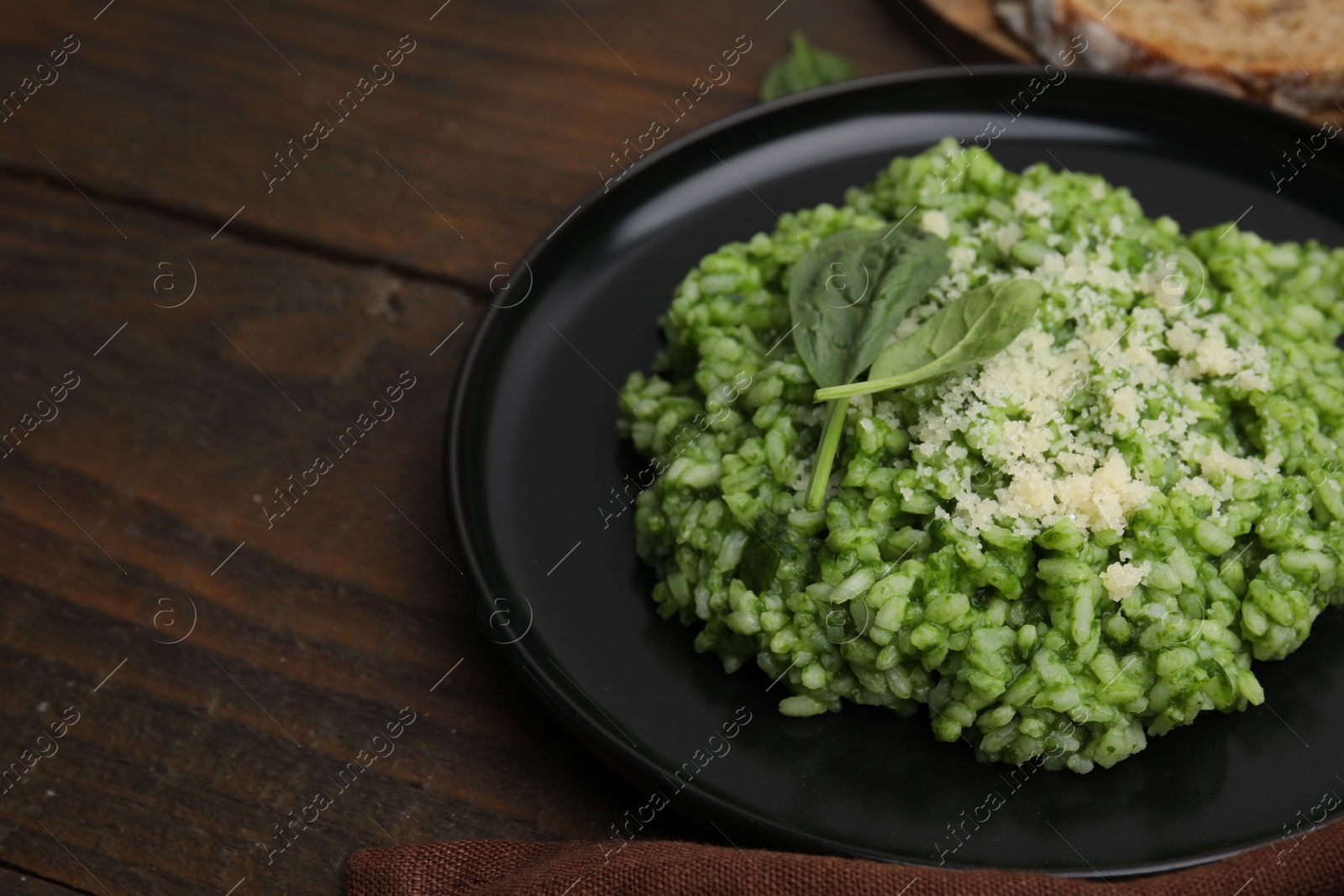 Photo of Delicious spinach risotto with parmesan cheese on wooden table, closeup. Space for text