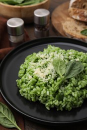 Photo of Delicious spinach risotto with parmesan cheese served on table, closeup