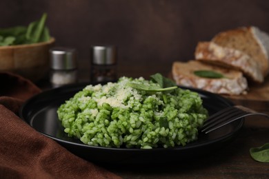 Photo of Delicious spinach risotto with parmesan cheese served on table, closeup