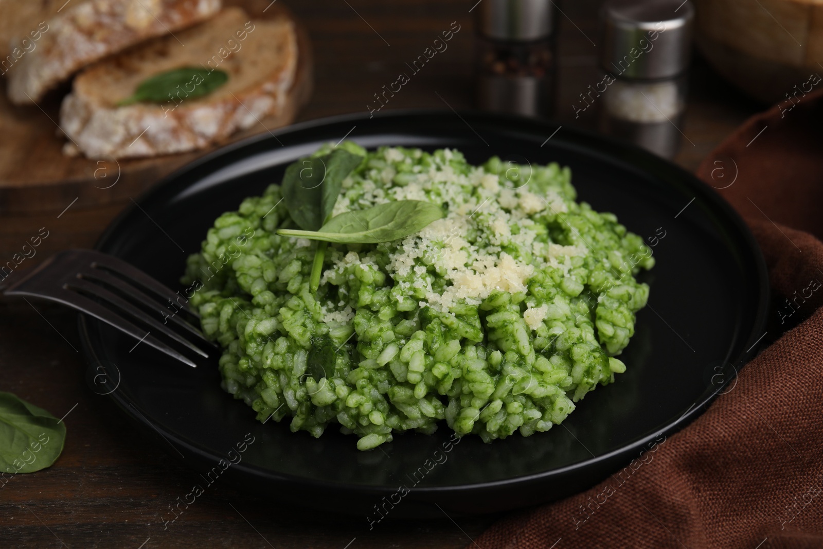 Photo of Delicious spinach risotto with parmesan cheese served on table, closeup