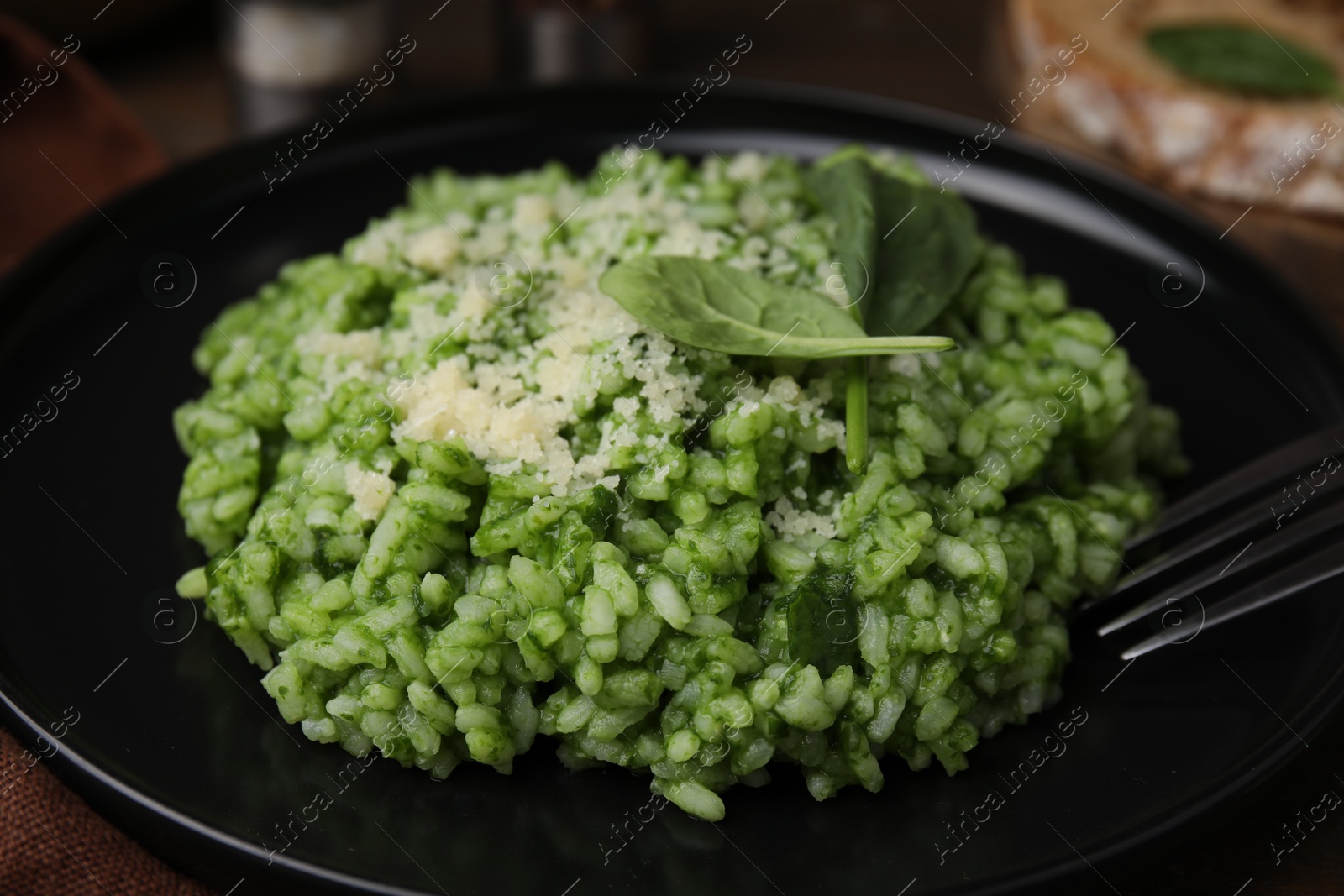 Photo of Delicious spinach risotto with parmesan cheese served on table, closeup