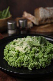 Photo of Delicious spinach risotto with parmesan cheese served on table, closeup