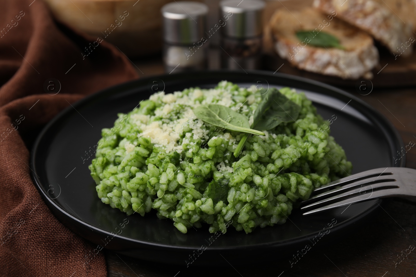 Photo of Delicious spinach risotto with parmesan cheese served on table, closeup