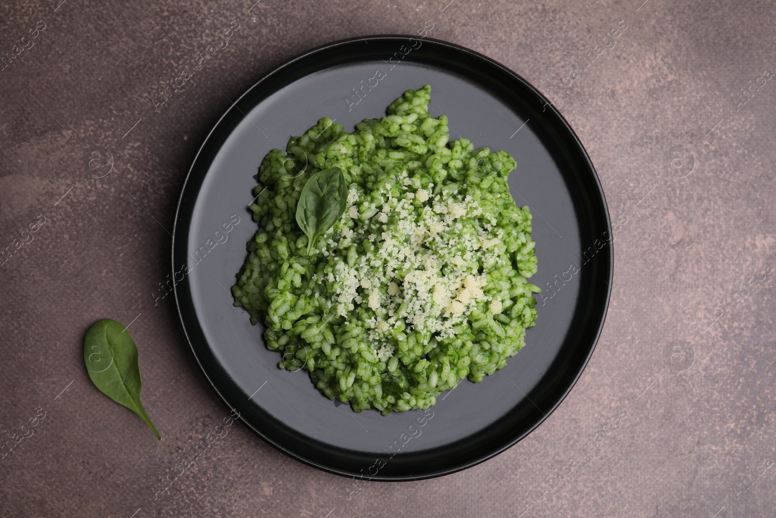 Photo of Delicious spinach risotto with parmesan cheese on grey table, top view