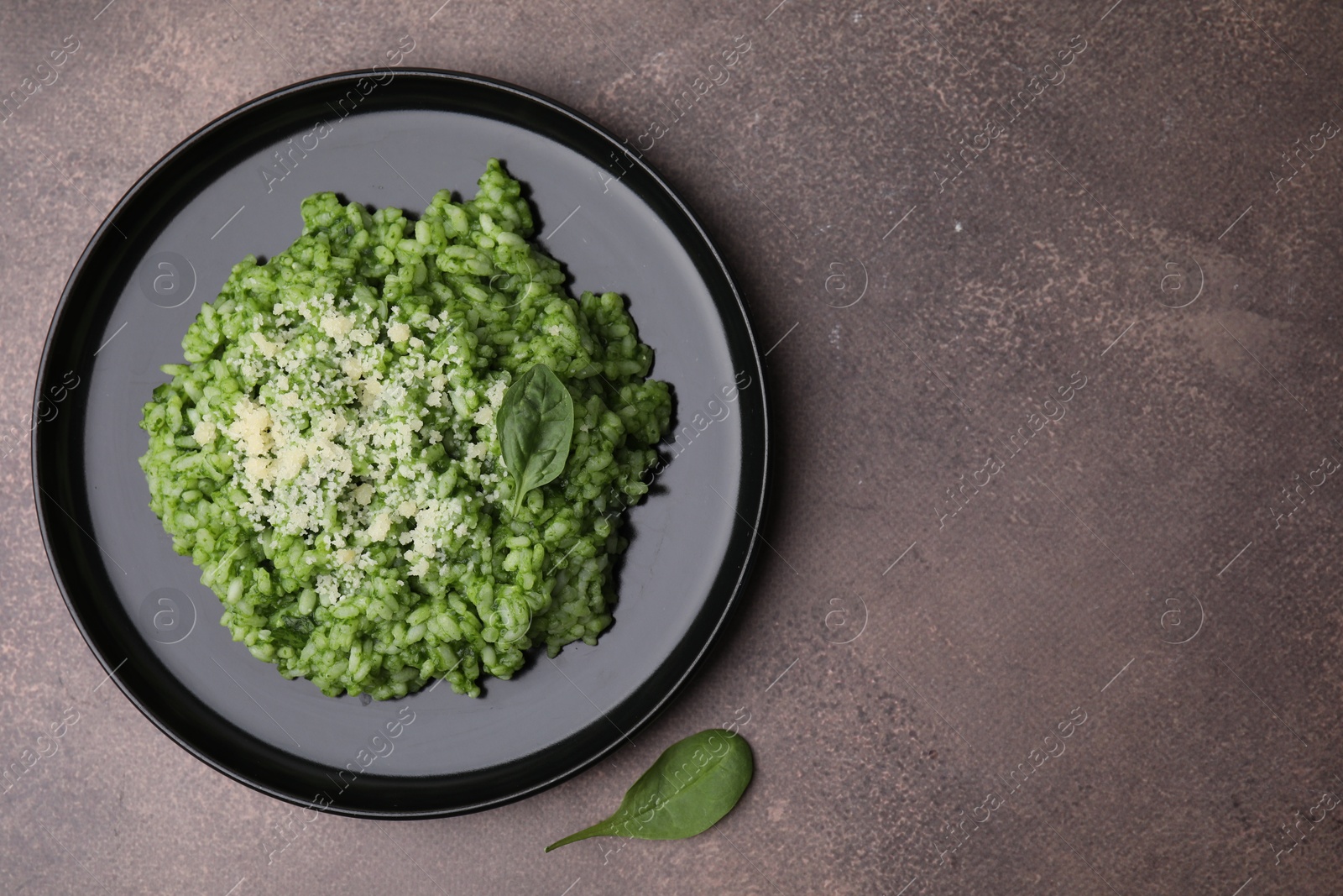 Photo of Delicious spinach risotto with parmesan cheese on grey table, top view. Space for text