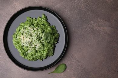 Photo of Delicious spinach risotto with parmesan cheese on grey table, top view. Space for text