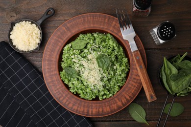 Photo of Delicious spinach risotto with parmesan cheese served on wooden table, flat lay