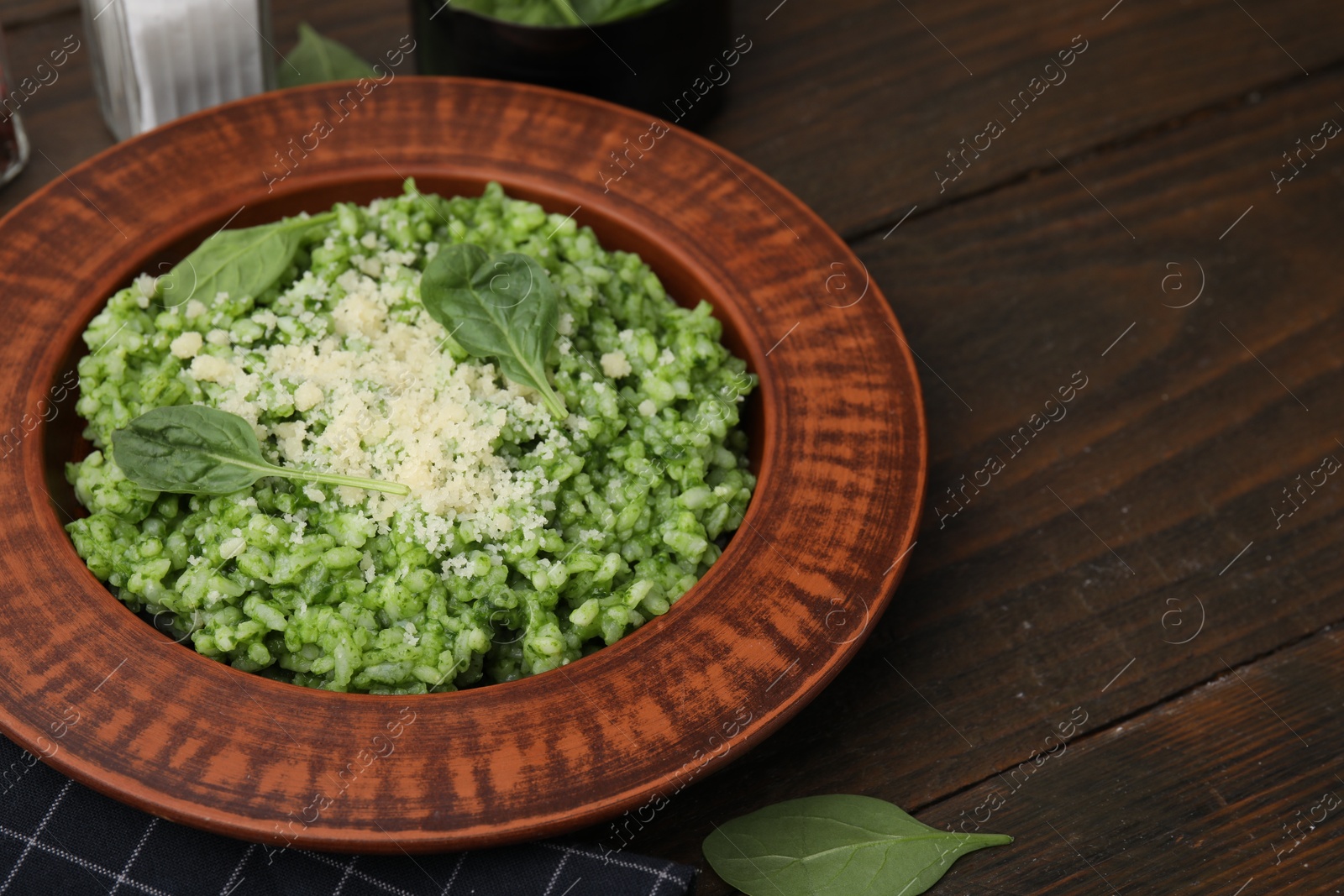 Photo of Delicious spinach risotto with parmesan cheese on wooden table, closeup. Space for text