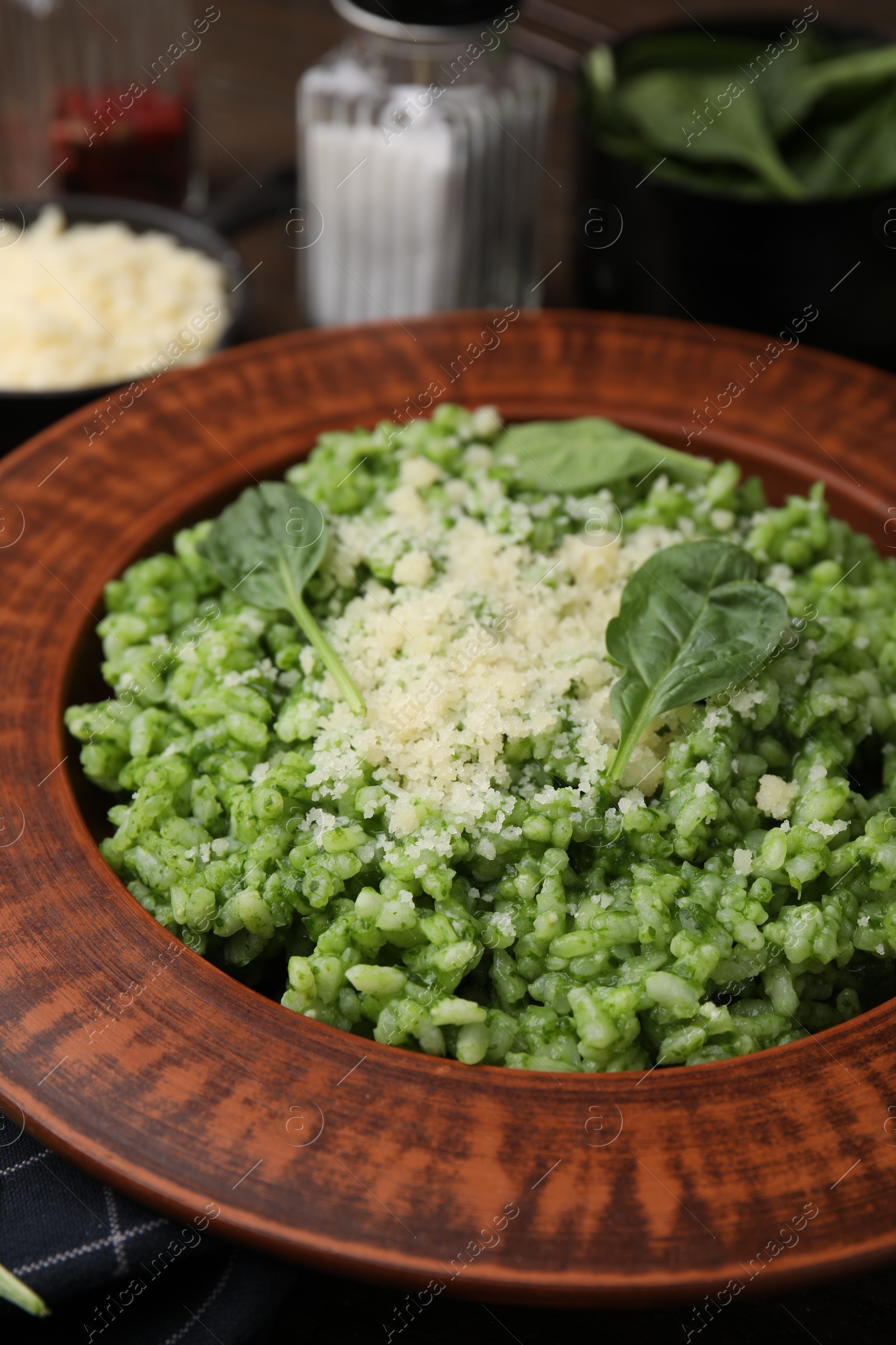 Photo of Delicious spinach risotto with parmesan cheese on wooden table, closeup