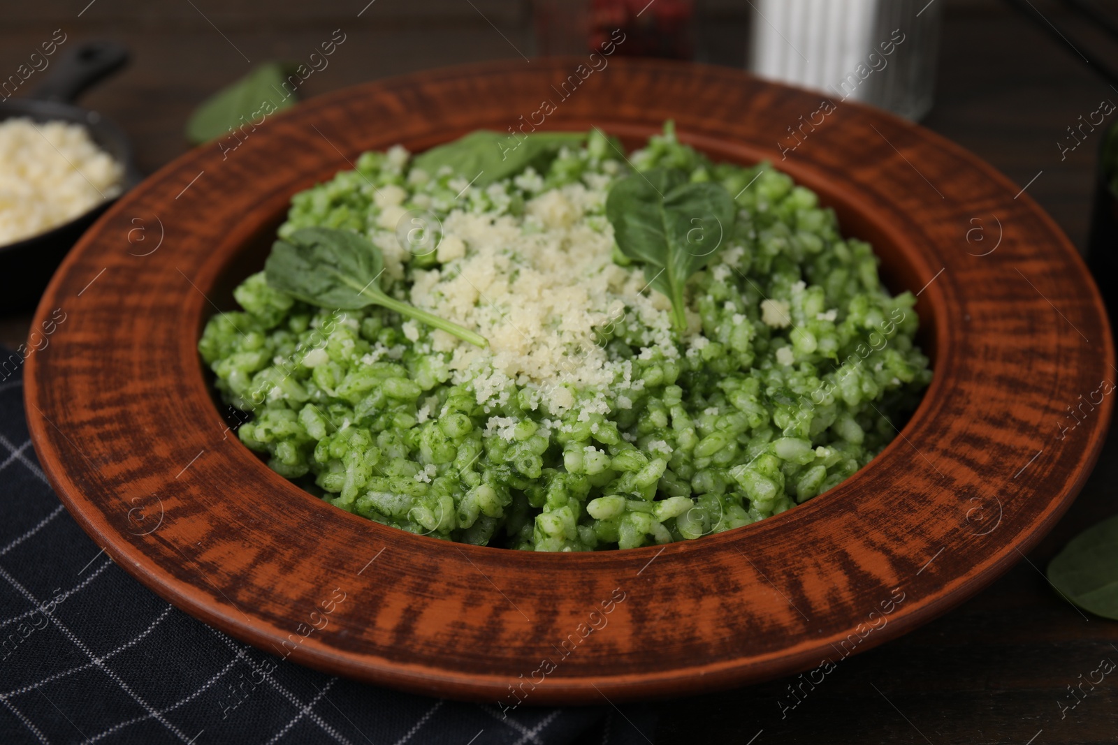 Photo of Delicious spinach risotto with parmesan cheese on wooden table, closeup