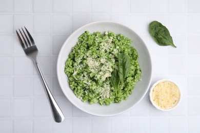 Photo of Delicious spinach risotto with parmesan cheese served on white tiled table, flat lay