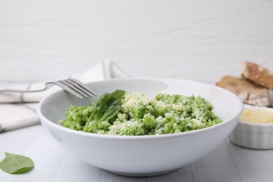 Photo of Delicious spinach risotto with parmesan cheese served on white tiled table, closeup